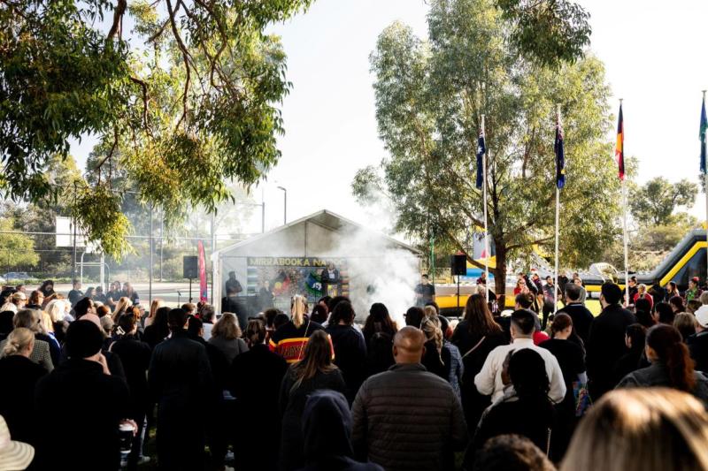 A crowd of people around a circle where smoke rises from